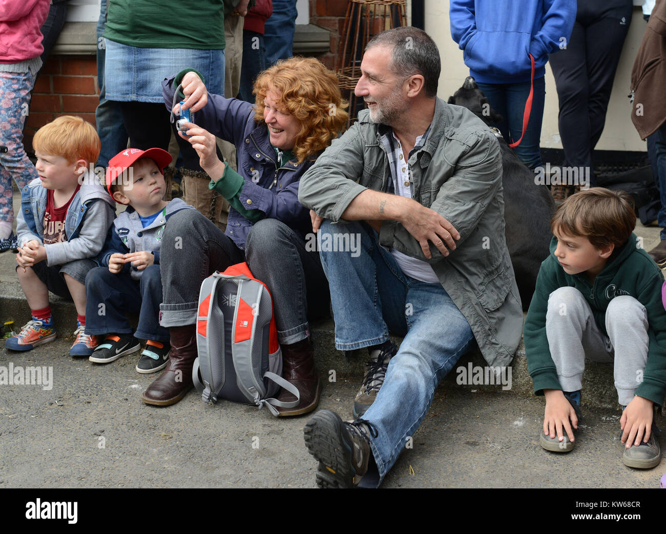 Famiglia seduta nel frenare la visione di spettacoli di strada il Green Man Festival a Clun nello Shropshire Foto Stock