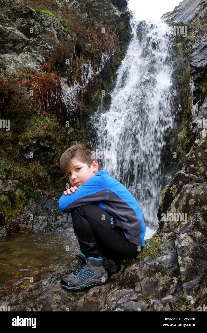 Ragazzo giovane bambino camminare vicino a cascata sulla lunga Mynd hill in Shropshire England Regno Unito Foto Stock