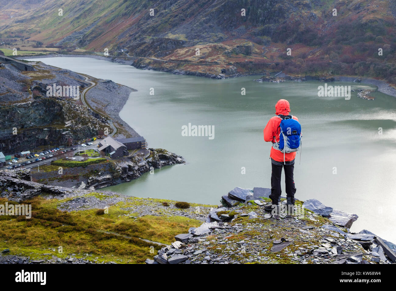 Escursionista nella cava di Dinorwig guardando a vista al di sopra Dinorwig power station ingresso e Llyn Peris in valle. Dinorwic Llanberis Gwynedd Wales UK Gran Bretagna Foto Stock