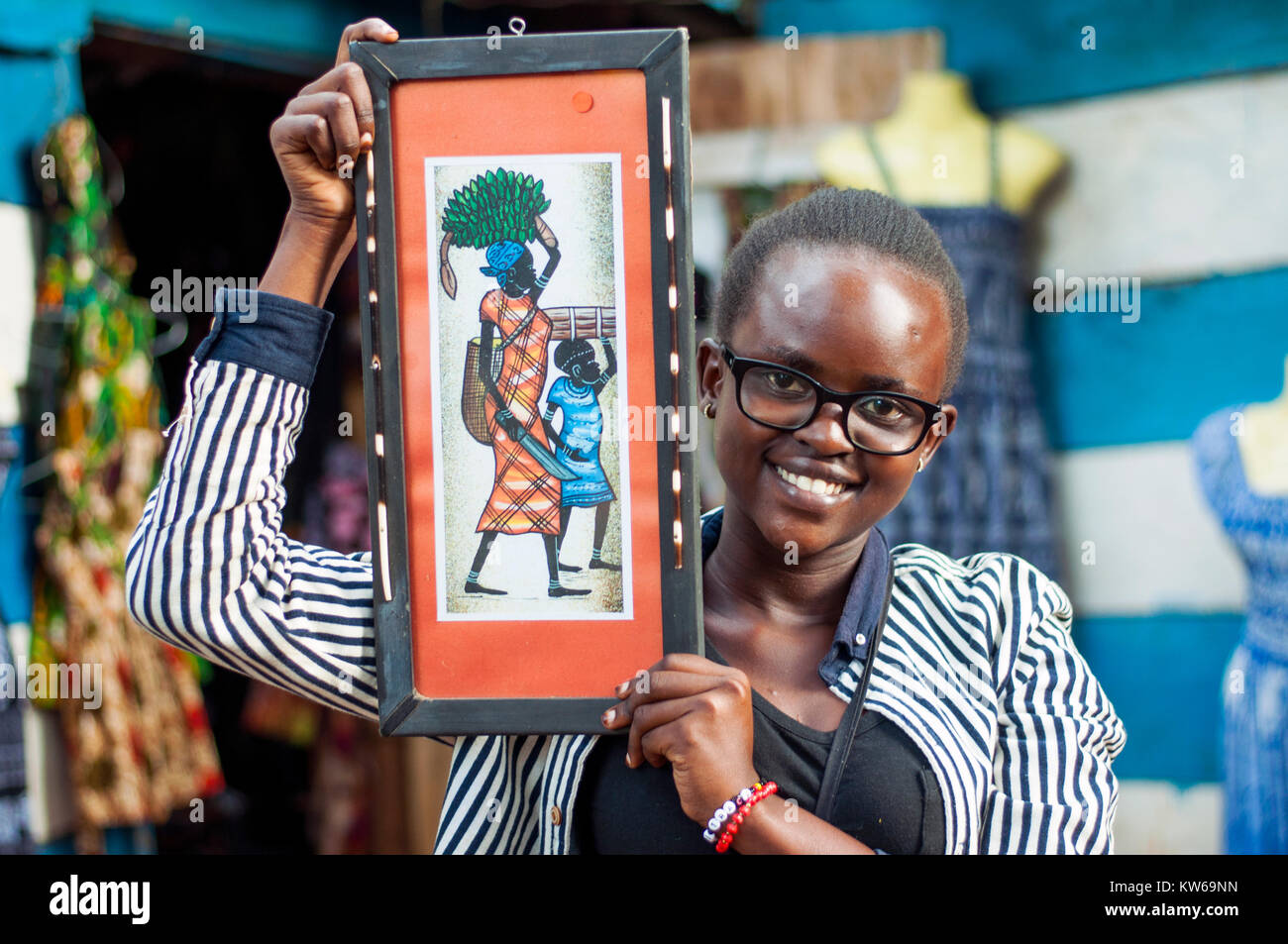 Titolare di stallo holding incorniciato pittura tribale, Craft Centre Entebbe, Wakiso, Uganda Foto Stock