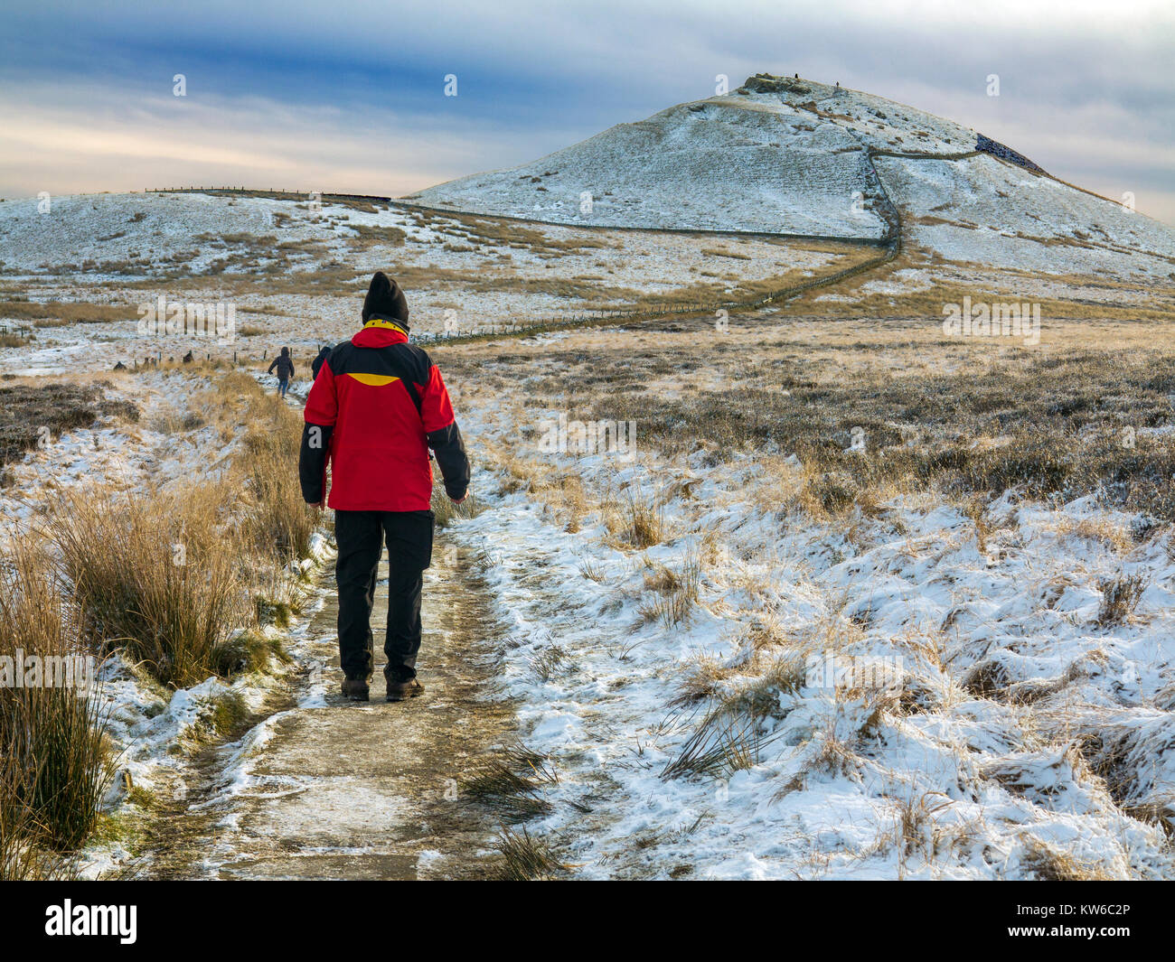 Uomo che cammina verso la collina di Shutlingsloe nella neve il terzo punto più alto del Cheshire a 506 metri dall'avvicinamento attraverso la foresta di Macclesfield Foto Stock