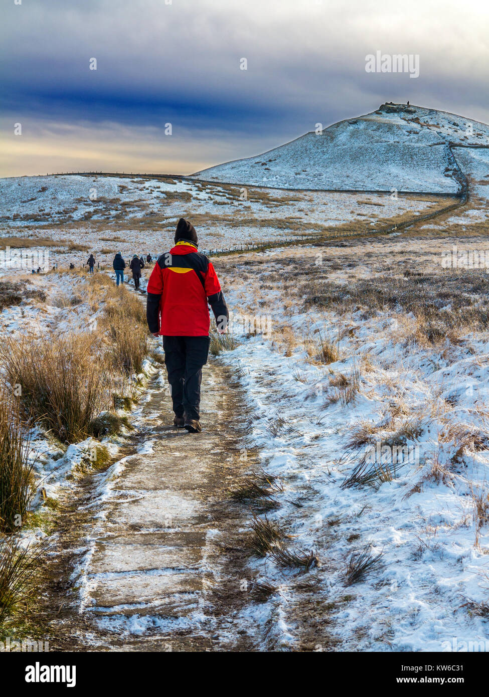 Uomo che cammina verso la collina Shutlingsloe nella neve il terzo punto più alto nel Cheshire a 506 metri dall'approccio attraverso la foresta a Macclesfield Foto Stock