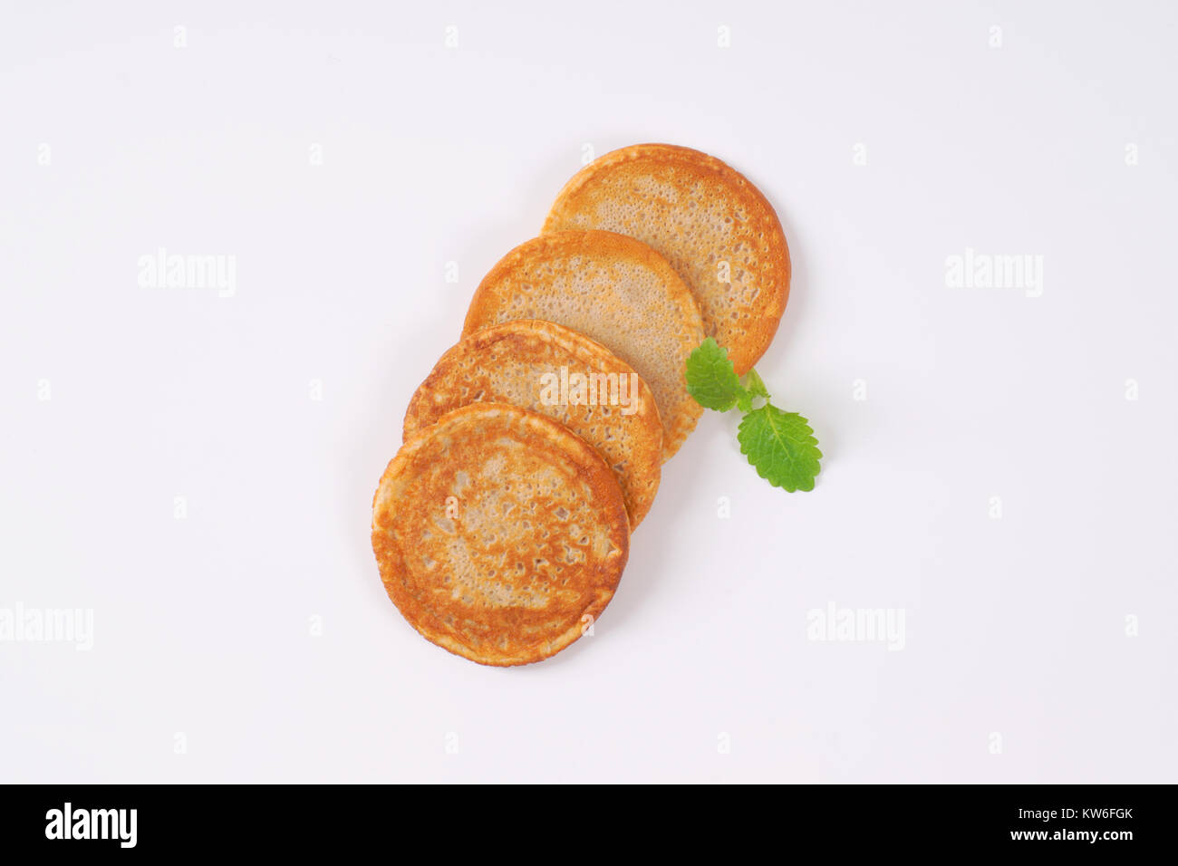 Piccole gustose frittelle su sfondo bianco Foto Stock