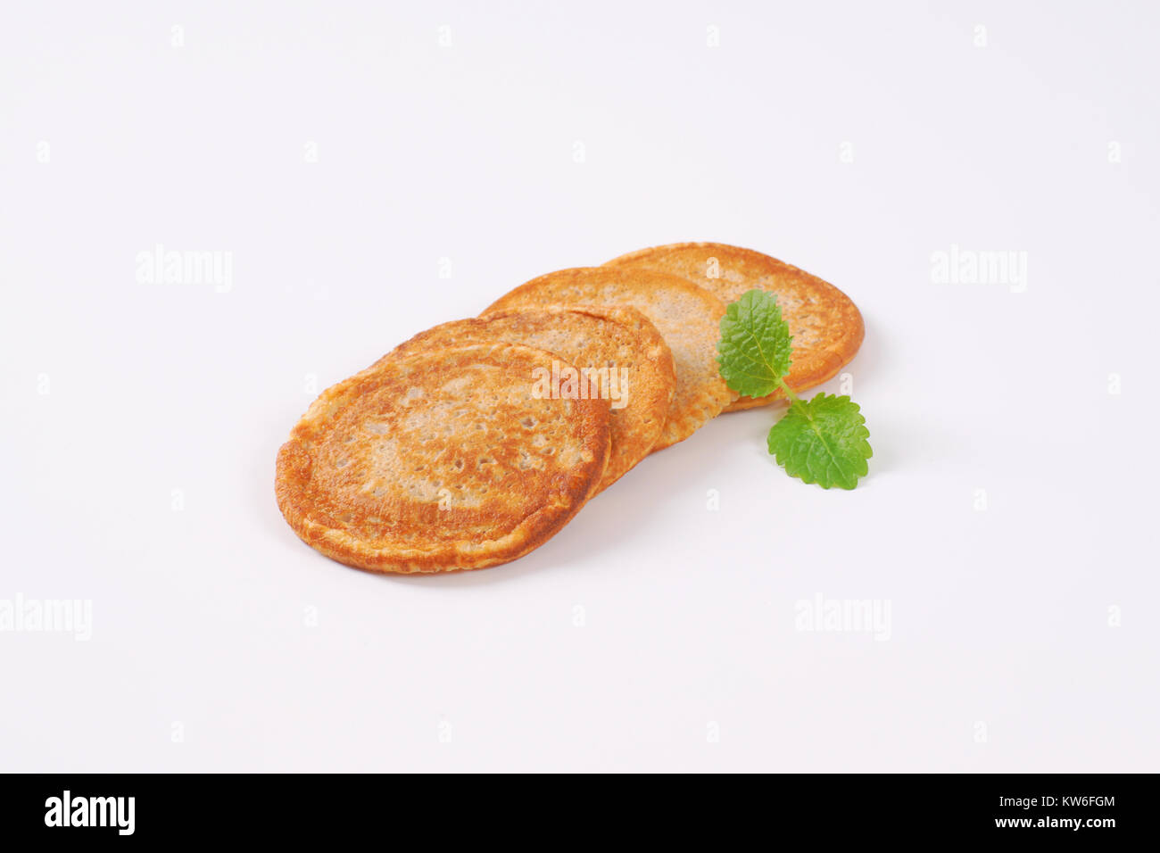 Piccole gustose frittelle su sfondo bianco Foto Stock