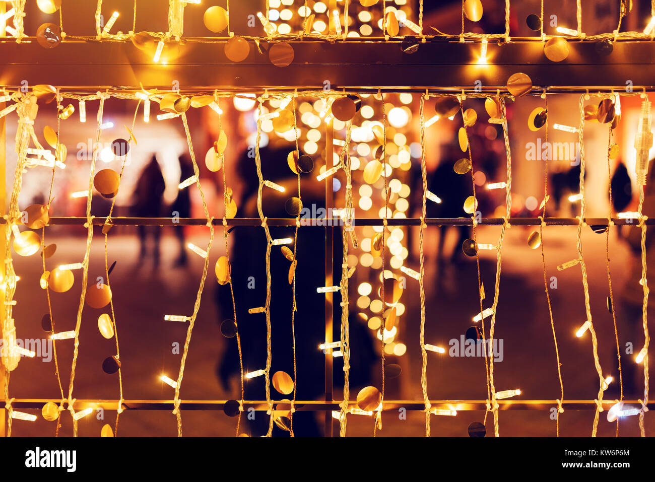 Blur sagome, la folla di gente che cammina sulla strada decorate durante la stagione delle feste come il Natale e il nuovo anno, decorazione luminosa bokeh come astratta ho Foto Stock