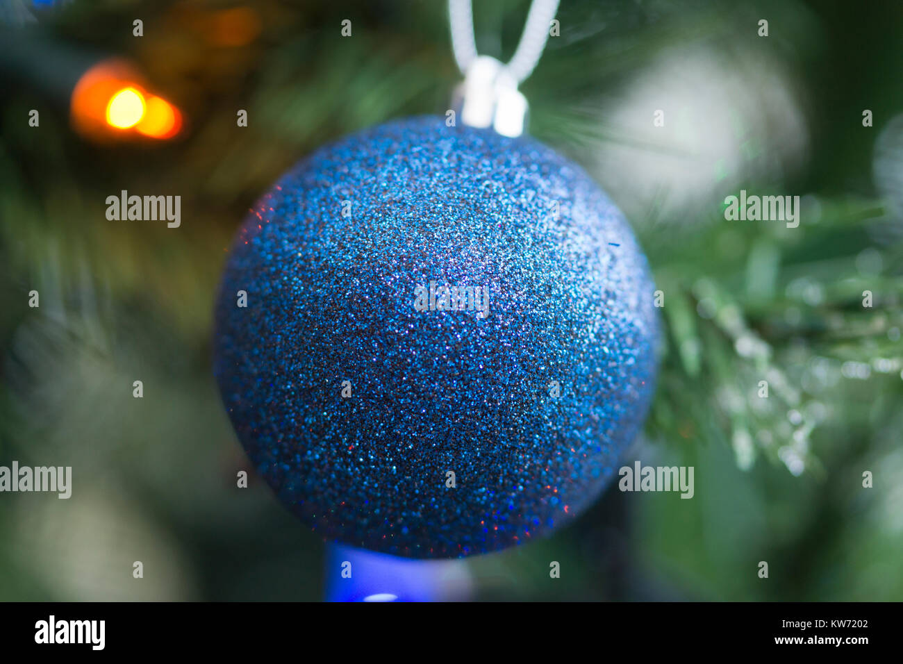 Un closeup di una singola decorazione blu bauble appeso da a. Albero di Natale Foto Stock