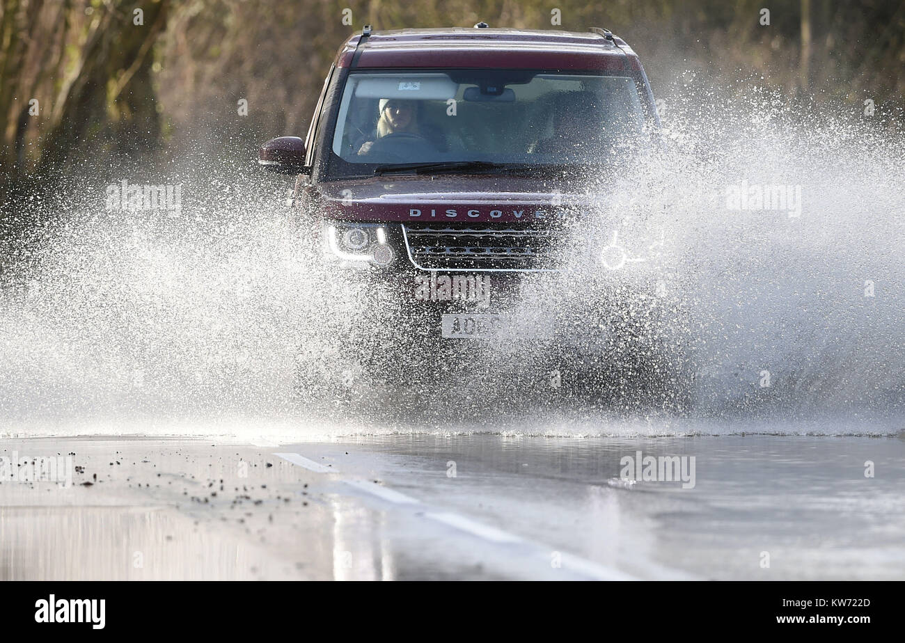 Le automobili fanno la loro strada attraverso l'acqua di allagamento nei pressi Chediston nel Suffolk, come tempesta Dylan è atteso per causare la distruzione in tutto il paese come il meteo porta anteriore di un umido e ventoso fine all'anno. Foto Stock