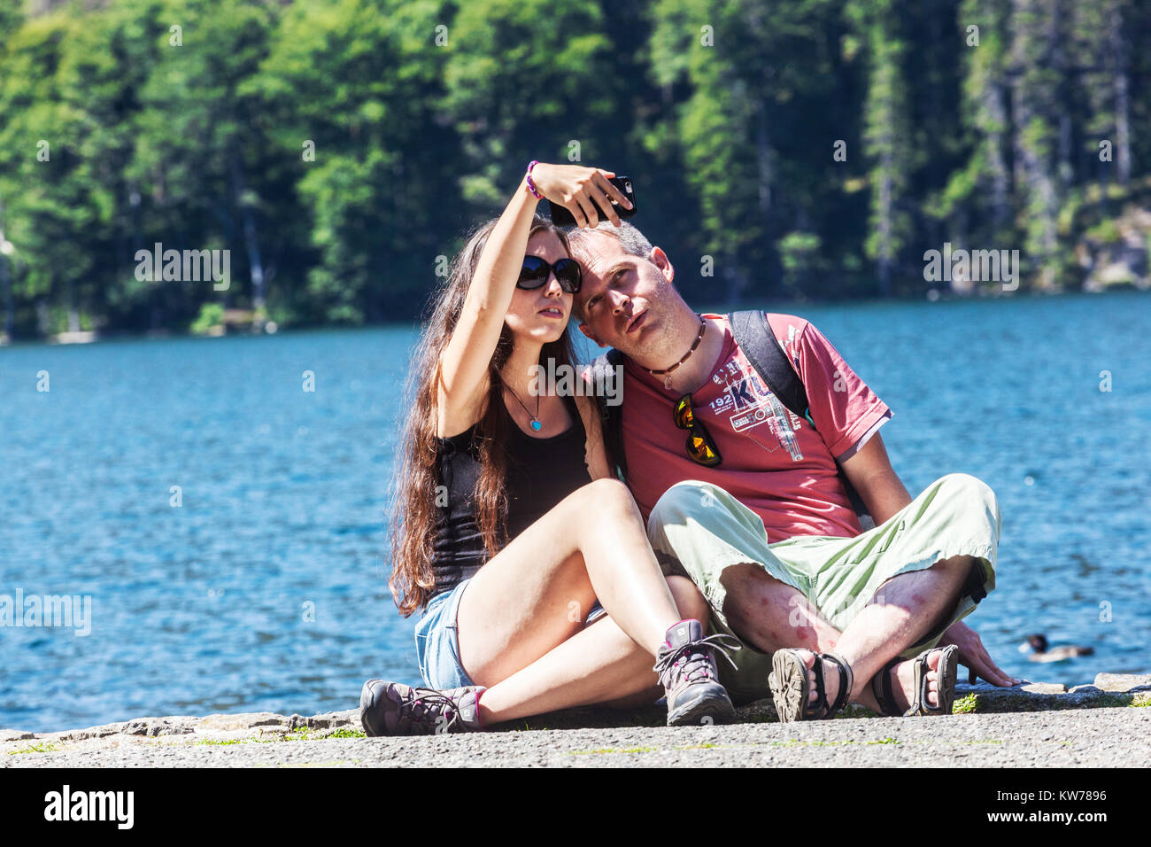 Gli escursionisti sulle rive del Lago Nero tenendo selfie, Sumava National Park, Repubblica Ceca Foto Stock