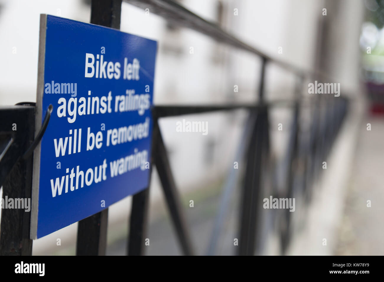 Segno "Biciclette a sinistra contro le ringhiere saranno rimossi senza avviso' Foto Stock