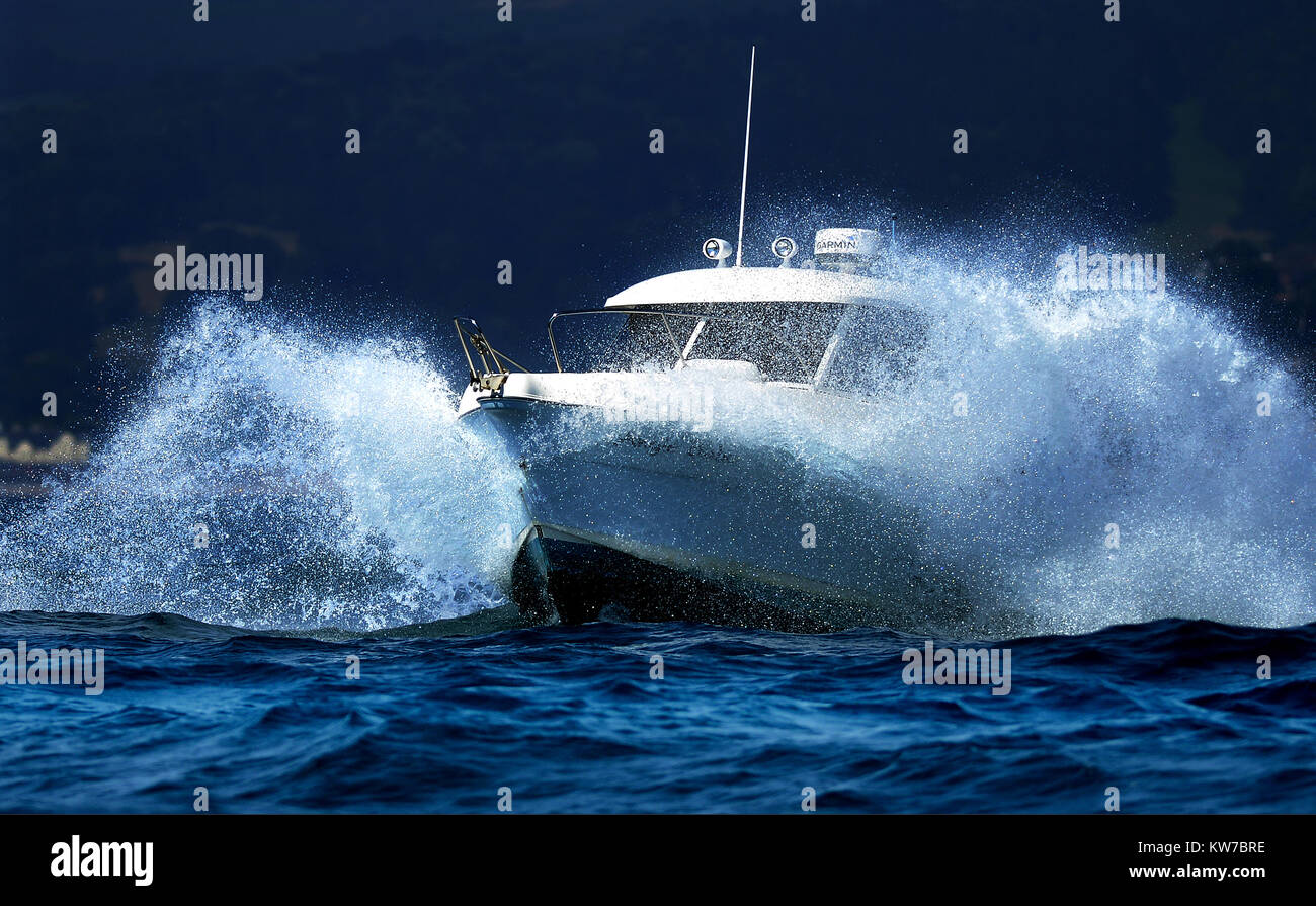 Un motoscafo schizzi mediante onde vicino a Exmouth, Devon, Foto Stock