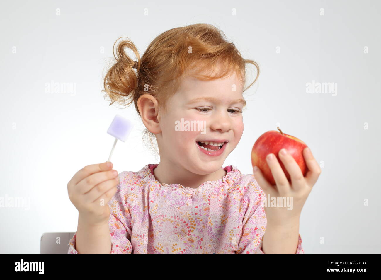 Un bambino preferendo healtthy cibi e dolci n. Foto Stock