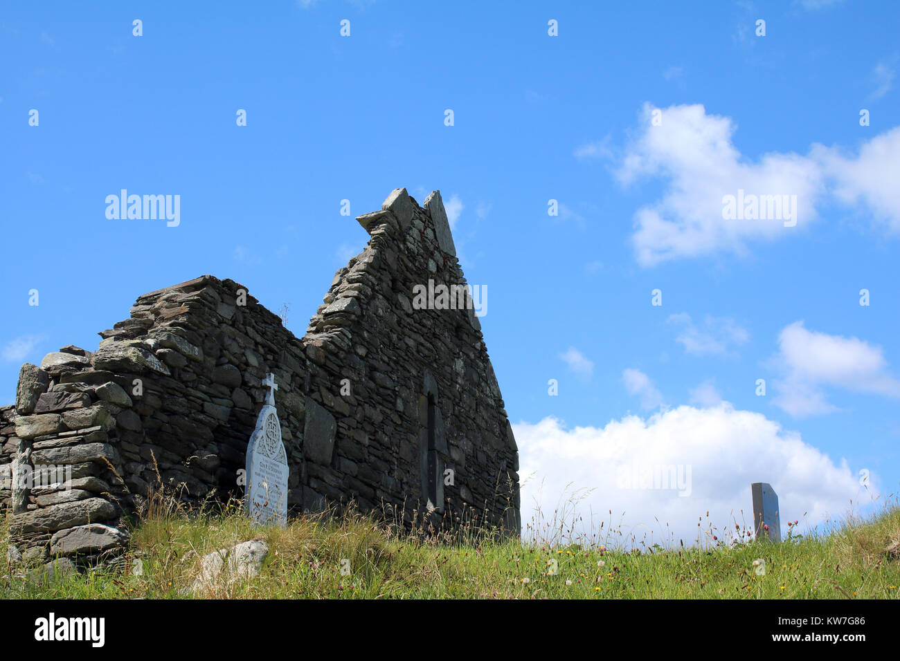 Rovina di una vecchia chiesa in pietra con monumenti religiosi situata nella parte occidentale di Cork in Irlanda Foto Stock