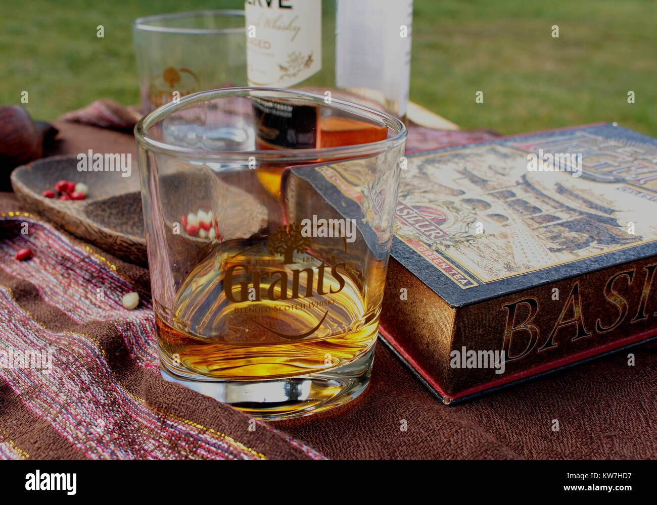 Ancora in vita per i colleghi - un bicchiere di whisky con bottiglia di whisky, ciotola di legno e un libro Foto Stock