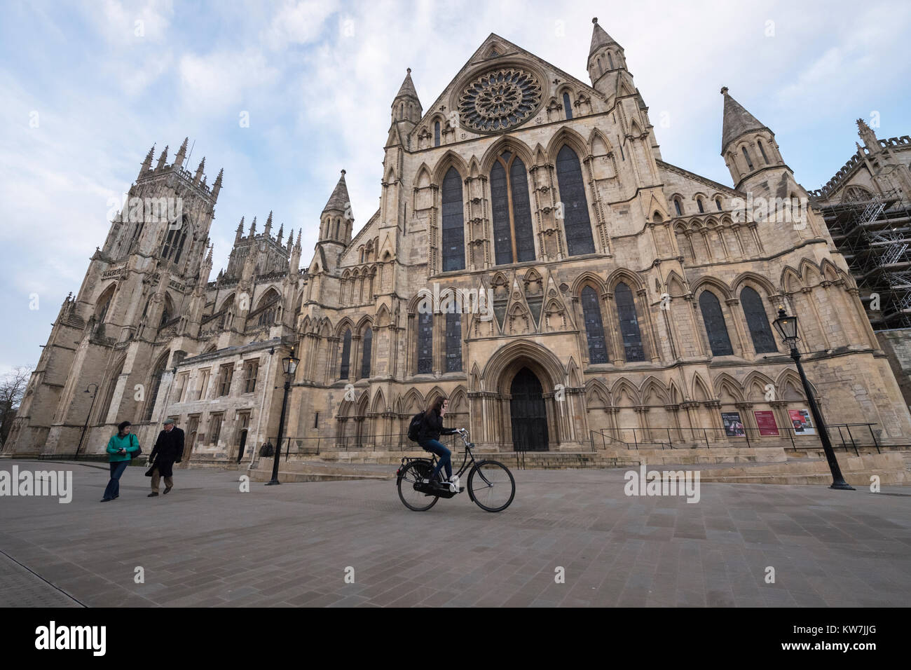 York Centre - ingresso sud alla magnifica cattedrale di York Minster da piazza dove la gente a piedi & femmina su cicli di telefono passato - North Yorkshire, Inghilterra, Regno Unito. Foto Stock