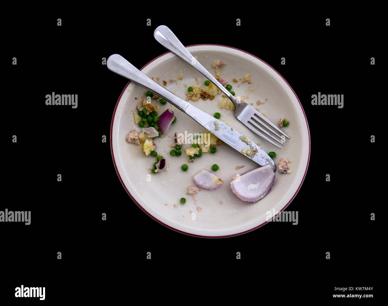 Scatto dall'alto di una piastra a vuoto con gli avanzi di un pasto su un backround nero Foto Stock