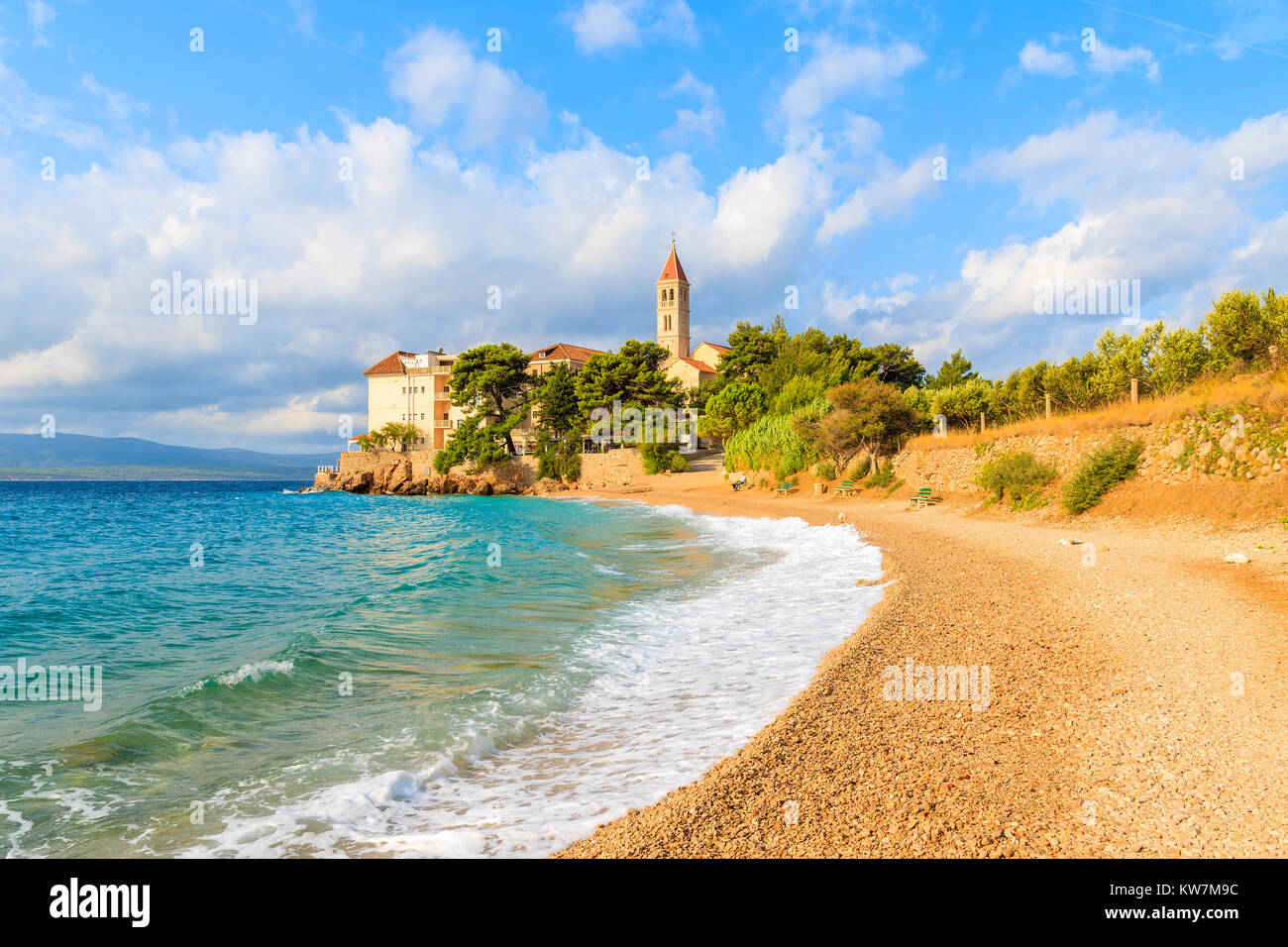 Onde sulla spiaggia con il famoso monastero domenicano nella città di Bol, isola di Brac, Croazia Foto Stock