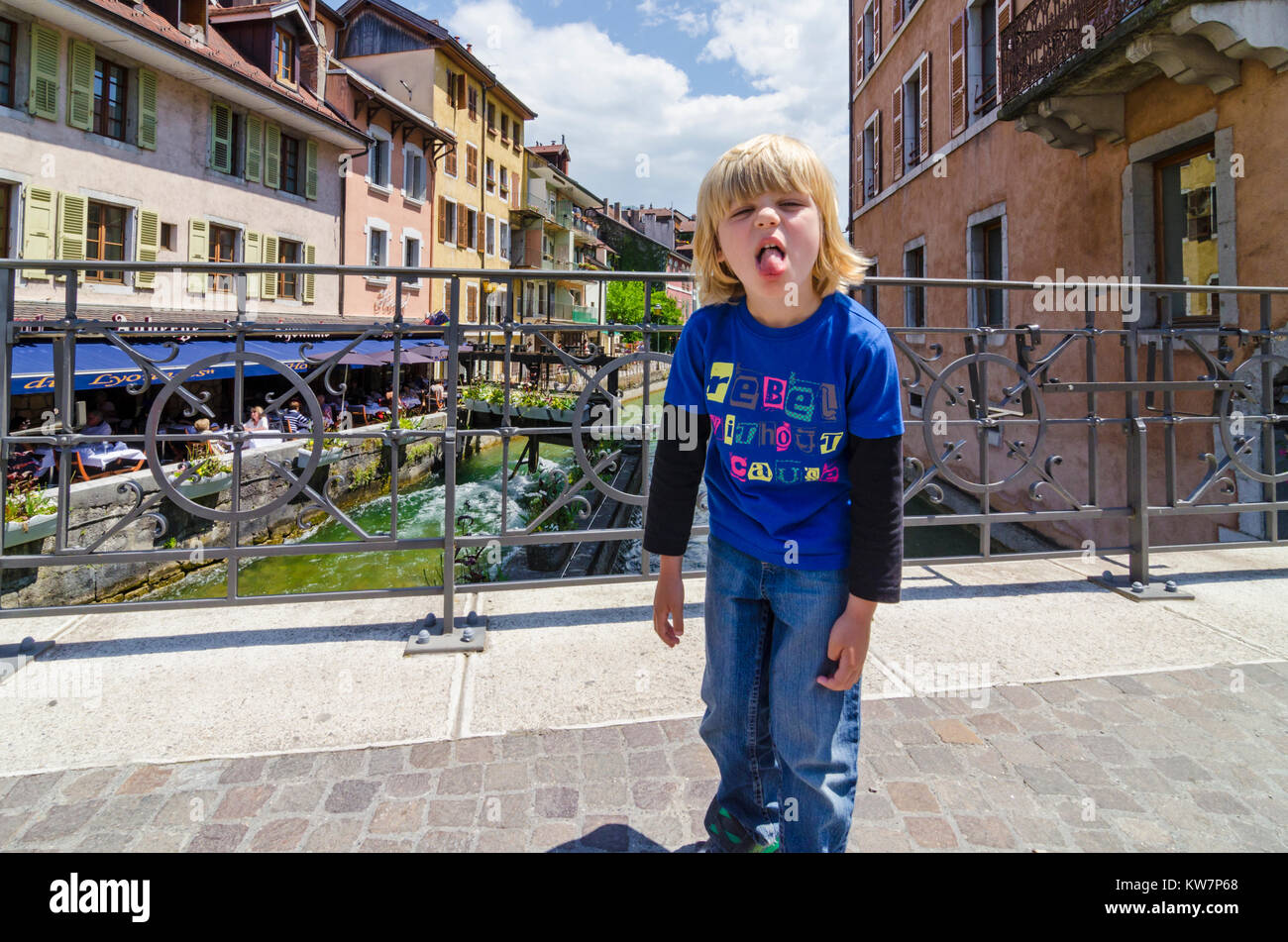 Bambino tirando la sua lingua fuori in fastidio mentre è in vacanza in Annecy, Francia Foto Stock