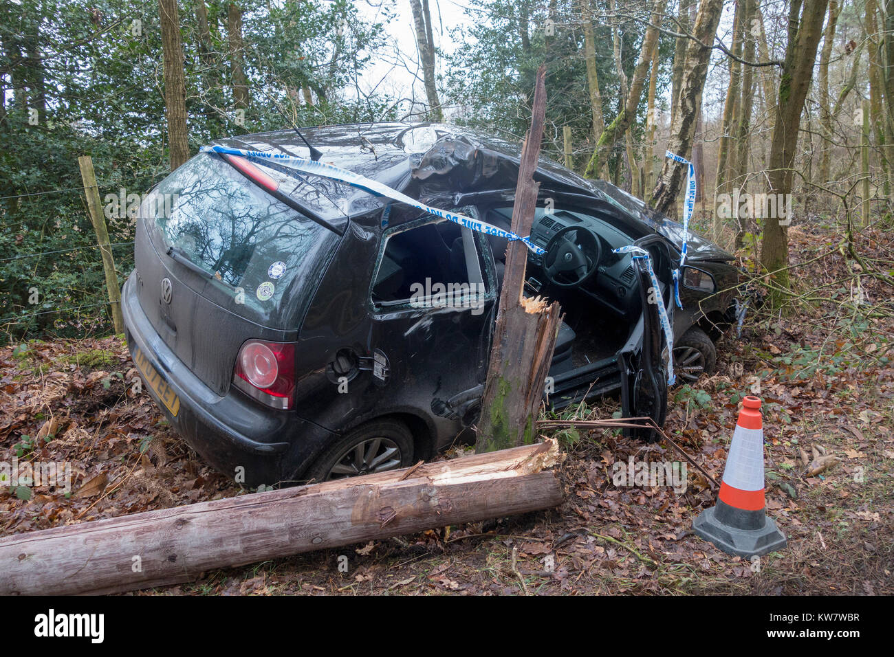 Un crash car, un nero Volkswagen Polo, in un vicolo del paese circondato dalla polizia a nastro avente a sinistra la strada e ha colpito un albero Foto Stock