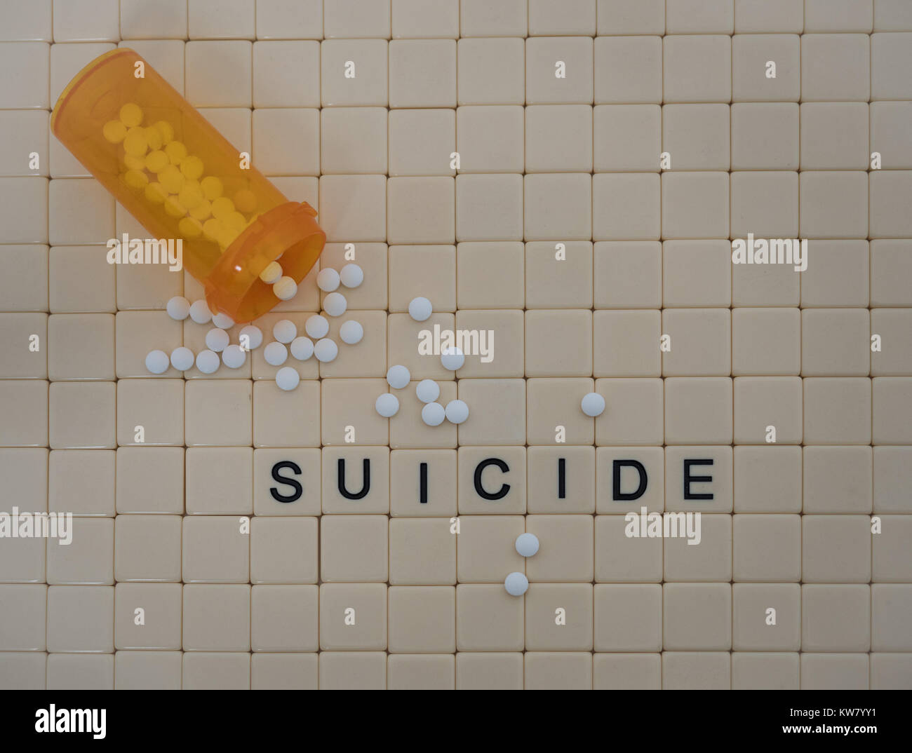 Tan piastrelle con lettere in nero il suicidio di ortografia su uno sfondo di piccole piastrelle beige e arancio aperto la bottiglia di prescrizione con il bianco di ossicodone pillole. Foto Stock