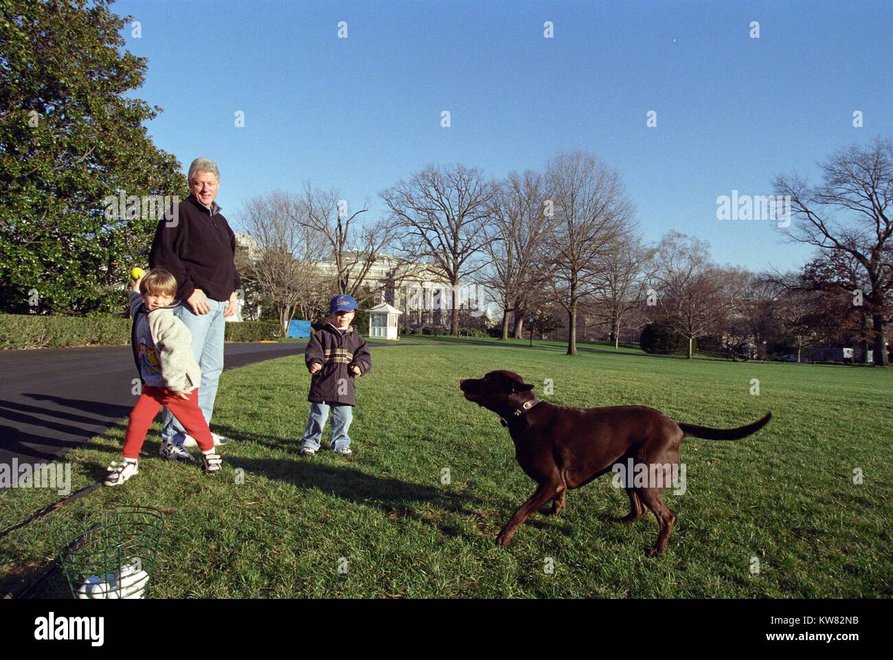 Il presidente William Jefferson Clinton e nipoti Tyler Clinton e Zach Rodham giocando con Buddy il cane sulla Casa Bianca prato, Dicembre 25, 1999. Foto Stock