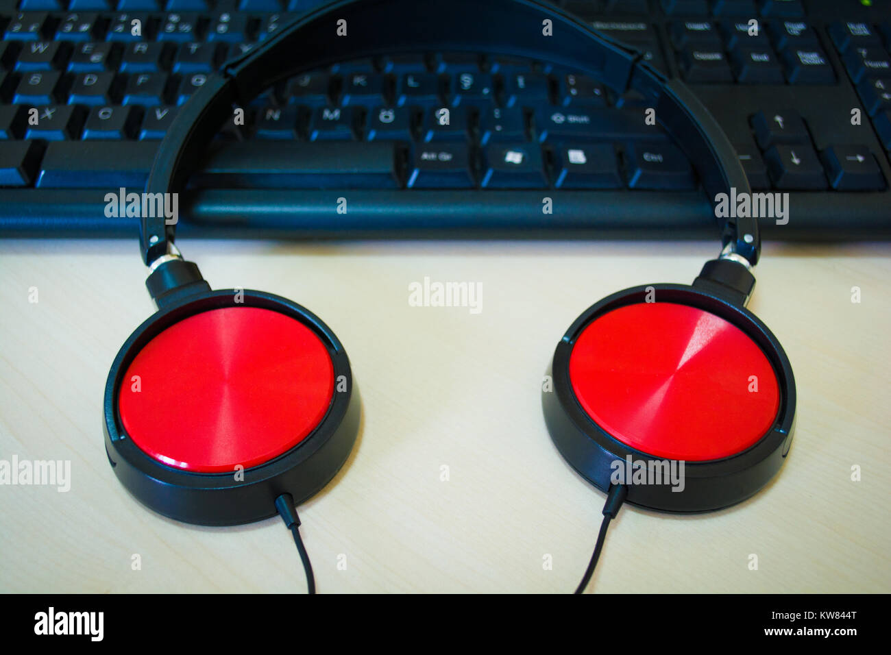 Creazione di musica digitale con tema professionale cuffie rosso sulla tastiera del computer Foto Stock