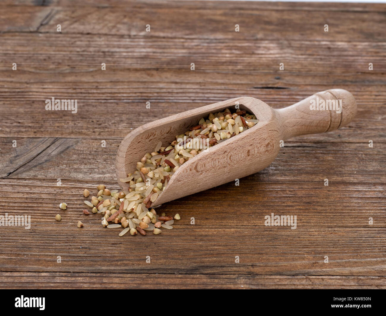 Riso a grani lunghi, in grani interi di riso rosso e grano saraceno. Mangiare sano per minestre o in alternativa alla semplice riso. Porzione in scoop. Foto Stock