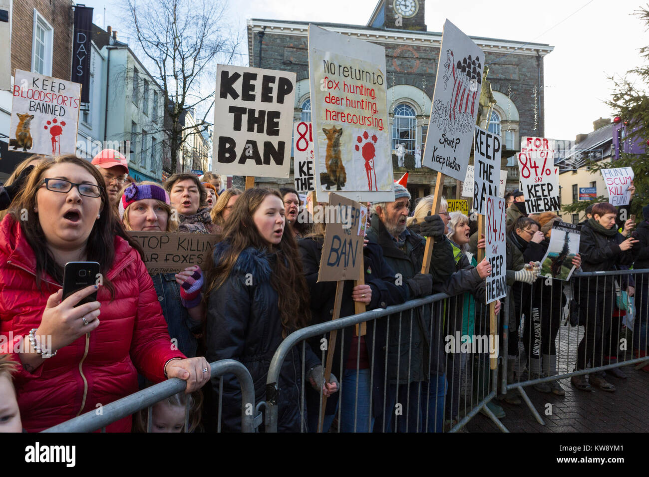 Manifestanti holding placards dimostrare contro la caccia alla volpe come la caccia Carmarthenshire parade attraverso Carmarthen il giorno di Capodanno 2018 Foto Stock