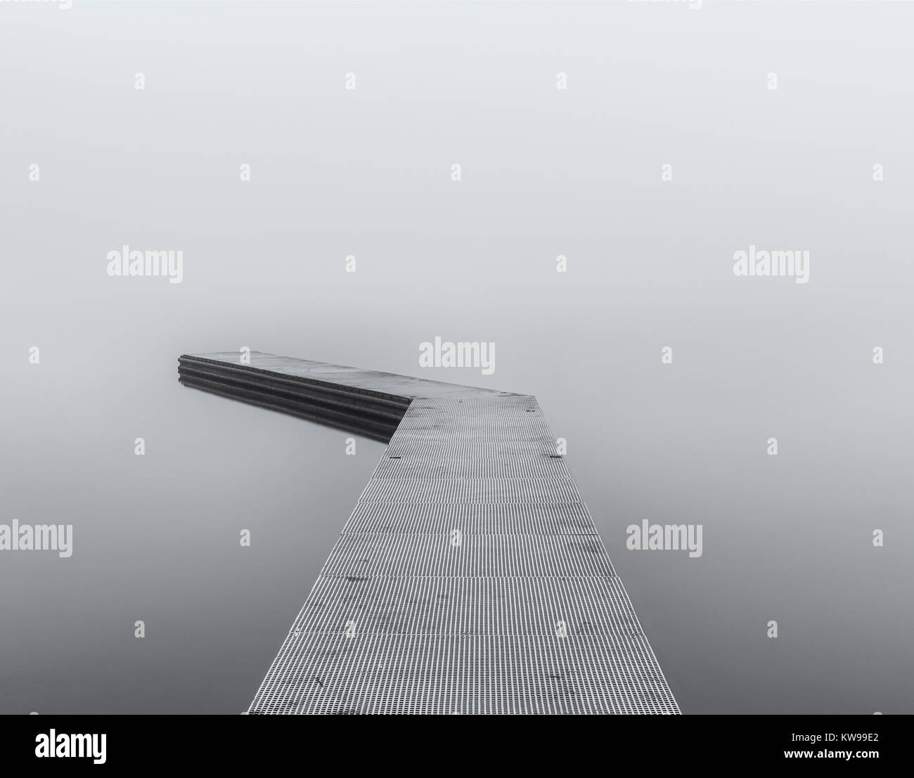 Una lunga esposizione di un lago marino jetty nella nebbia. Foto Stock