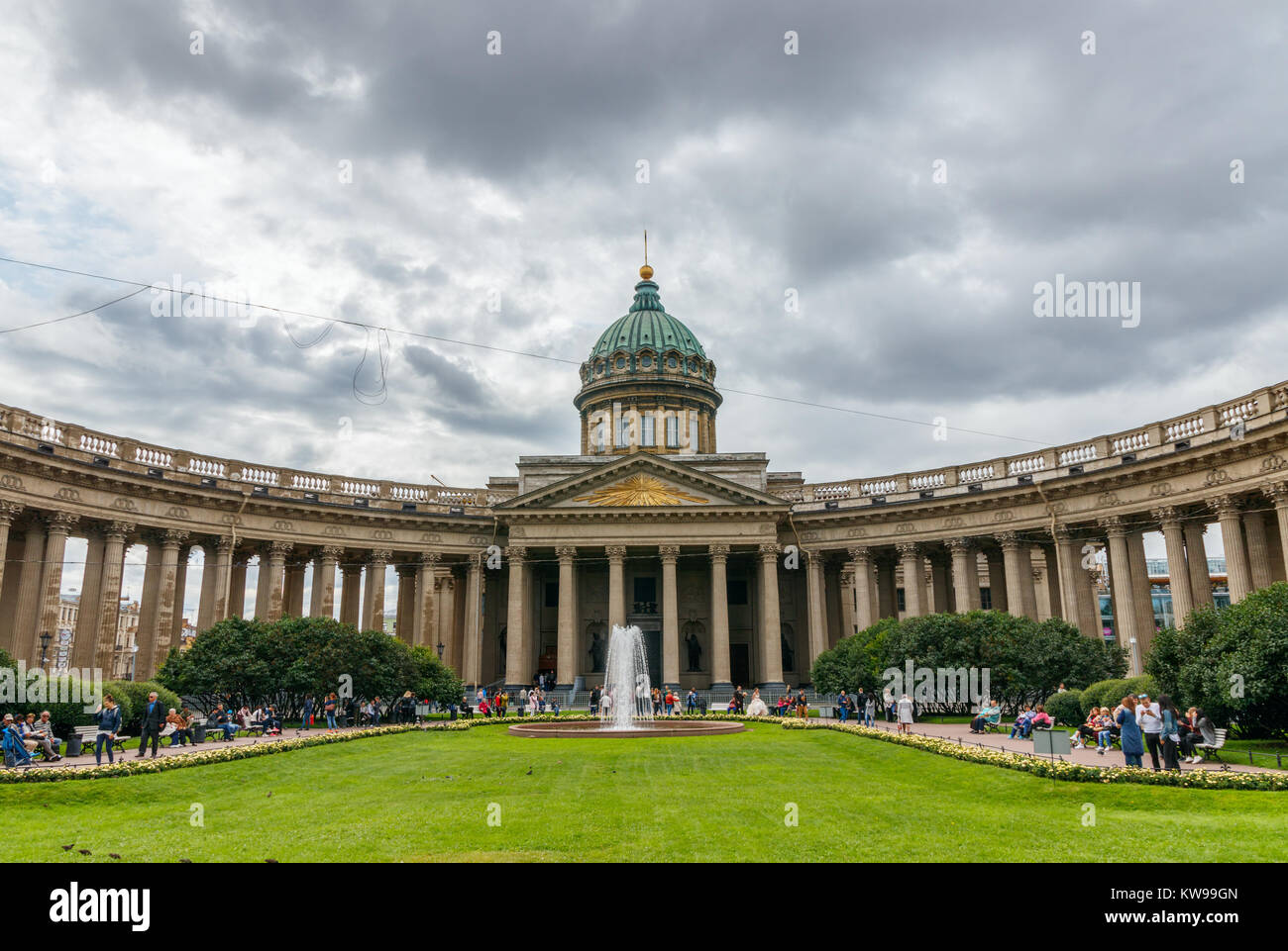 Parco con persone non identificate in fronrt del Kazanskiy Kafedralniy sobor (cattedrale Kazan) sotto un cielo nuvoloso. San Pietroburgo, Russia. Foto Stock