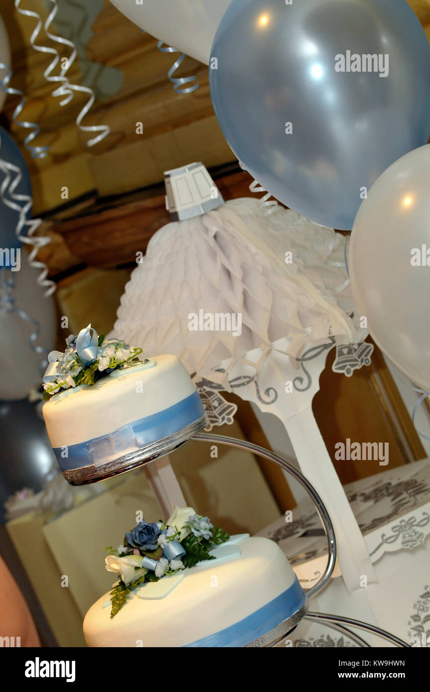 Una torta di nozze in tre livelli su una tabella insieme con altre decorazioni tavola per il grande giorno di nozze. Sposarsi e decorare la sala del ricevimento Foto Stock