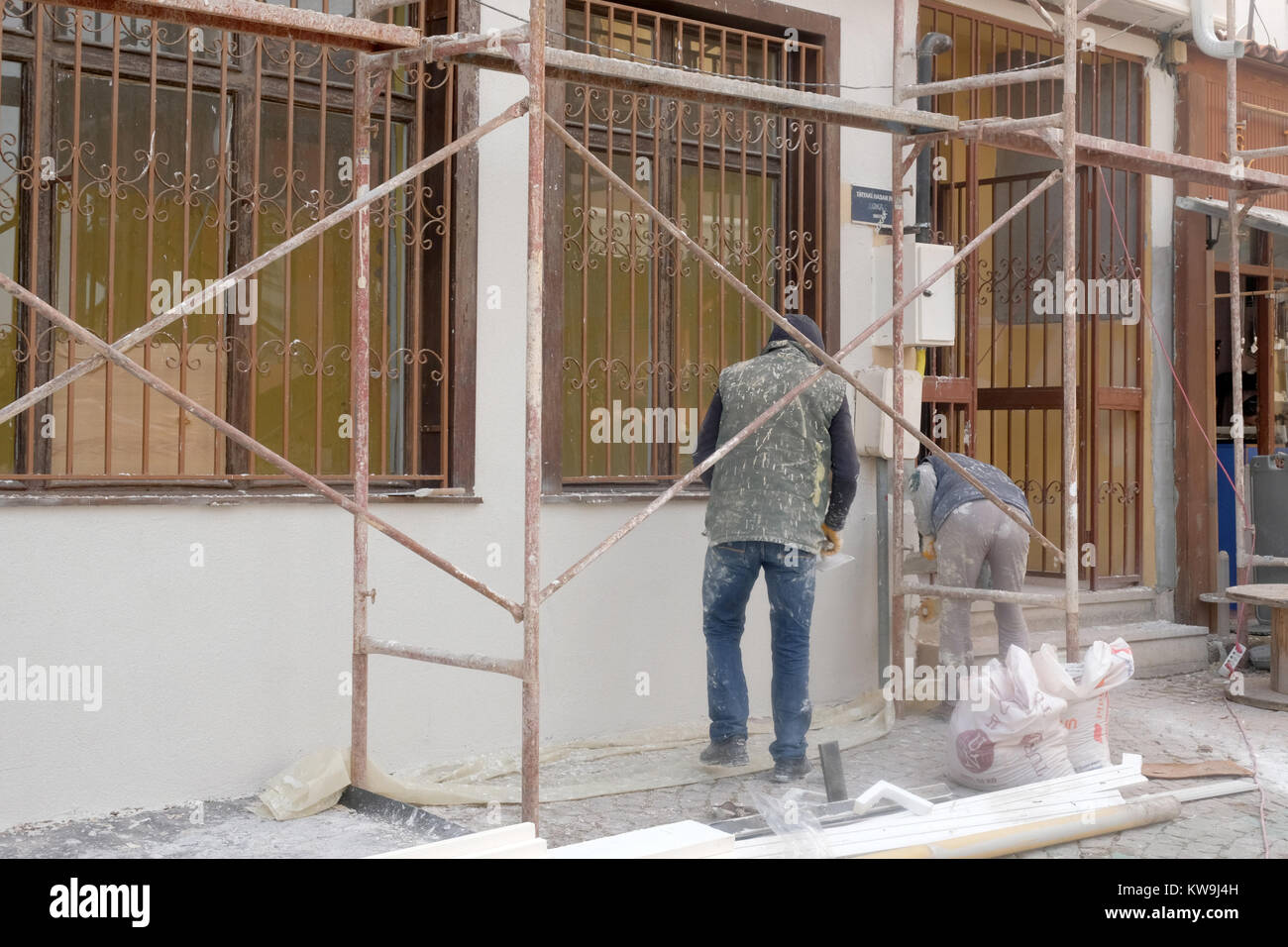 Dicembre 2017 - uomini al lavoro sulle pareti esterne di ripristinare una vecchia casa nella parte vecchia della città di Eskisehir, Turchia Foto Stock