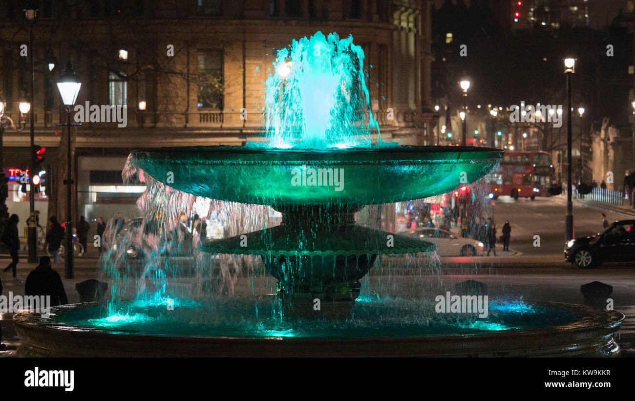 Verde di fontana illuminata di notte in Trafalgar Square, Londra Foto Stock