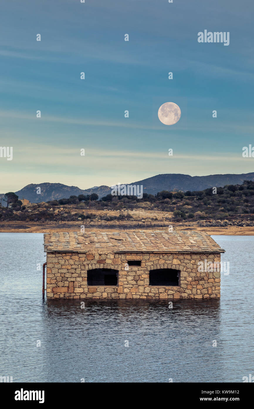 Full Moon Rising over parzialmente sommerso e abbandonato edificio in pietra in Lac de Codole lago nella regione della Balagne in Corsica Foto Stock