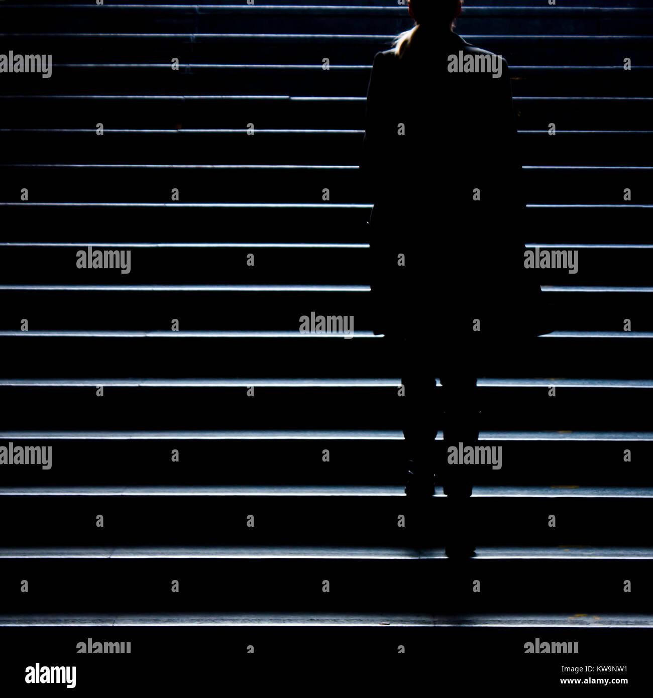 Urbano a piedi di notte : sfocata silhouette di un giovane ed elegante donna indipendente salendo per la strada di città scale pubbliche nella tranquilla moonlight , da sola, f Foto Stock