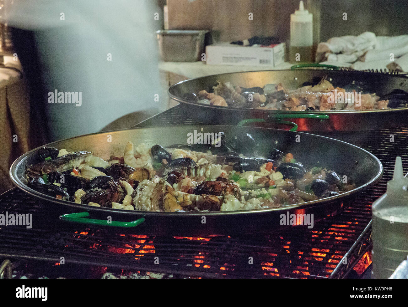 La paella di frutti di mare con gamberetti, capesante, aragosta e muscoli, saltate in padella su di un fornello da cucina Foto Stock