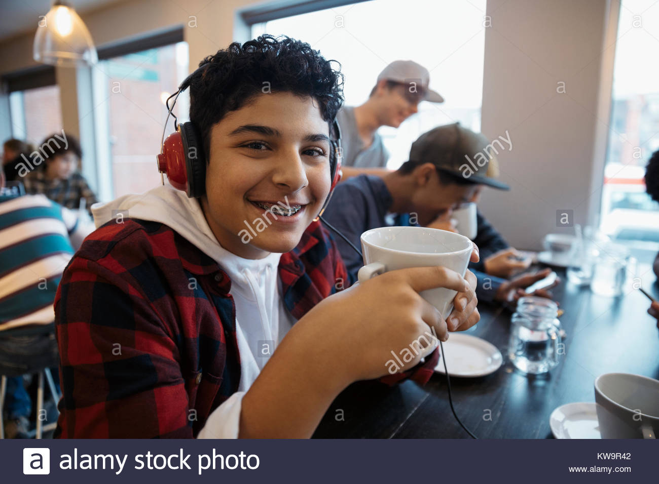Ritratto sorridente,fiduciosi nel Medio Oriente tween boy con cuffie di bere il caffè Foto Stock