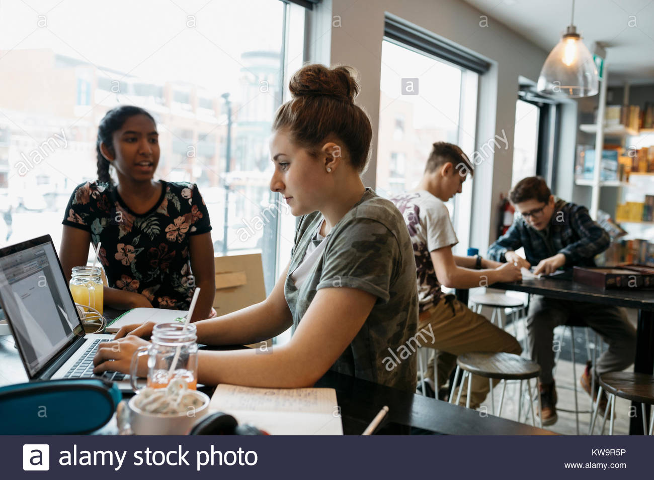 Alta scuola gli studenti che studiano,utilizzando laptop in cafe Foto Stock