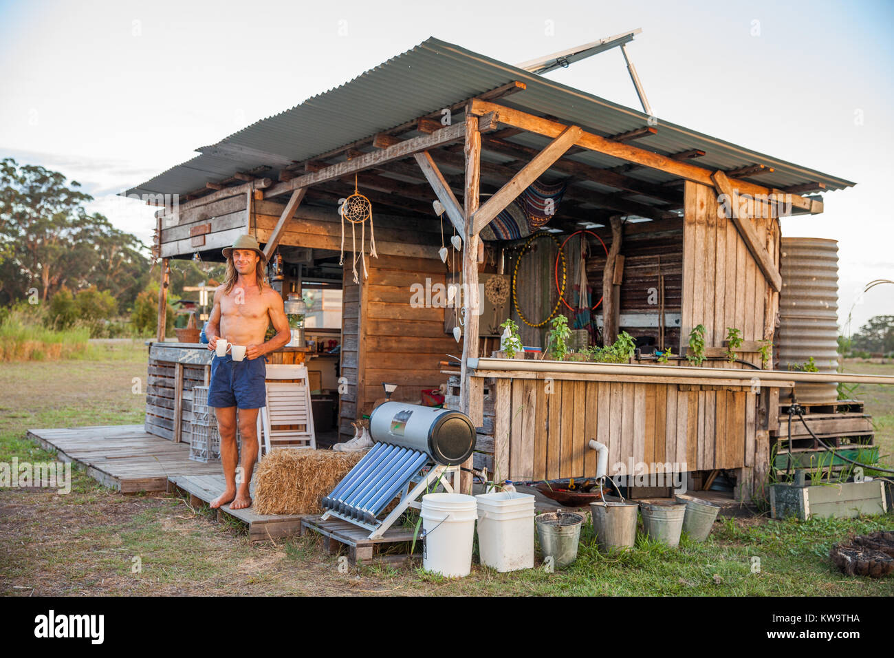 Uomo al di fuori off grid shack o capannone nel bush australiano Foto Stock