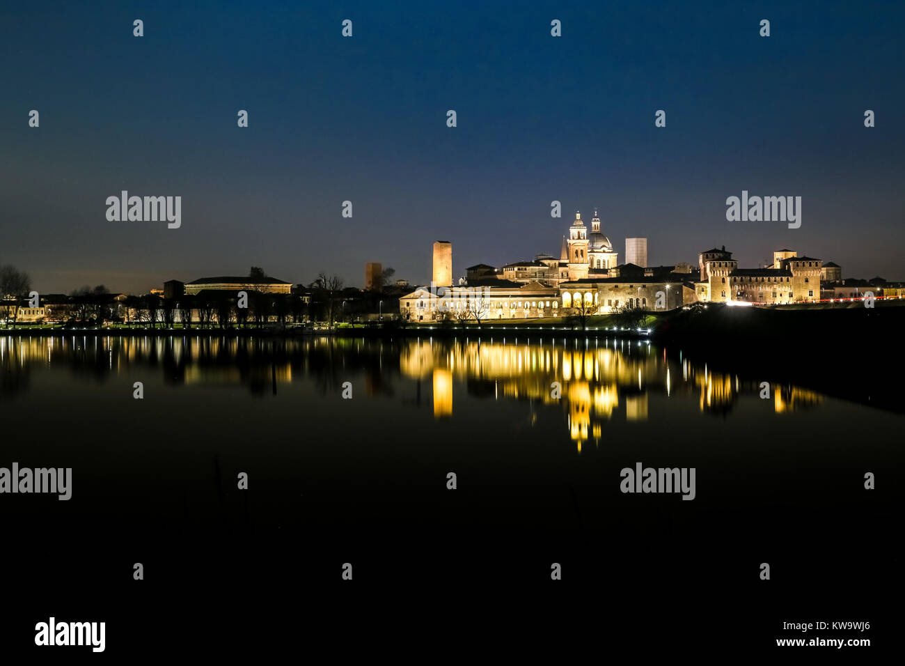 Il palazzo Ducale di Mantova, Italia, riflesso sul lago Mincio a notte. Mantova skyline notturno. Foto Stock