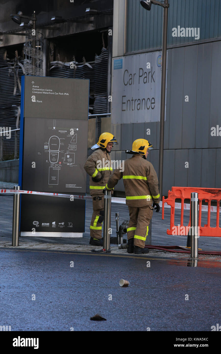 Fire equipaggi presso il parcheggio multipiano dell'hotel vicino alla Echo Arena di Liverpool, dopo l'ultima notte di fuoco che ha distrutto centinaia di vetture. Foto Stock