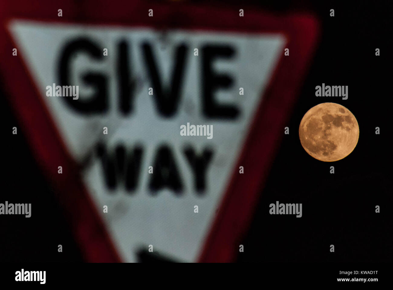 Leominster, UK. 1a gen, 2018. Regno Unito Meteo. La prima luna dell'anno e anche il primo supermoon dell'anno il lupo Luna è visto accanto a "dare modo' segnale illuminato il 1 gennaio 2018. Credito: Jim legno/Alamy Live News Foto Stock