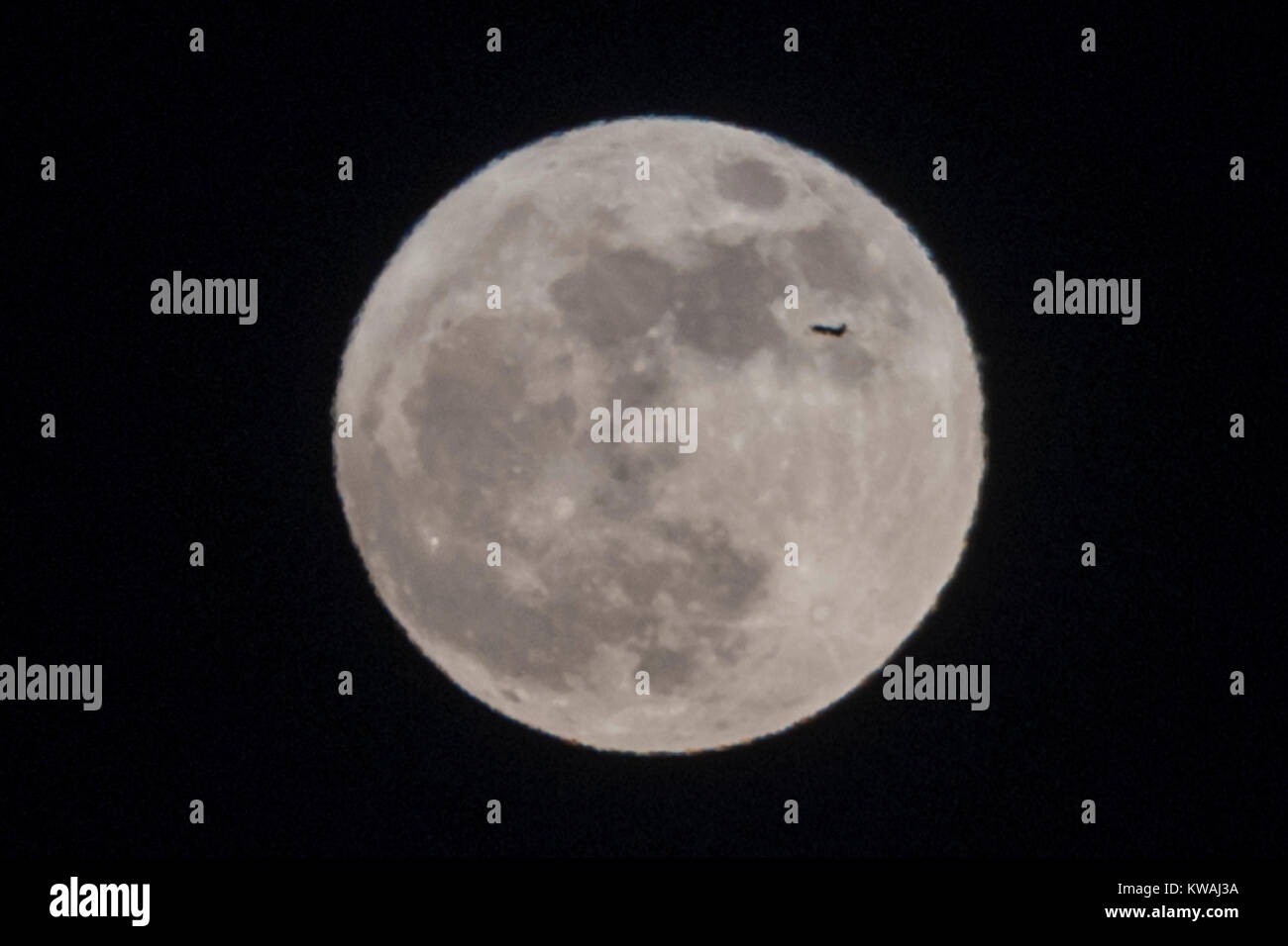 Chicago, Stati Uniti d'America. 1a gen, 2018. Un aereo passa attraverso la supermoon che salgono sopra il lago Michigan come si vede dal North Avenue beach il giorno di Capodanno. La luna è al suo punto più vicino, il perigeo, a terra durante la sua orbita mensile e compare il 30% più luminoso e 14% più grande. Gennaio 2018 vede un supermoon noto come 'Wolf moon" il 1 gennaio e un "Blue Moon" il 31 gennaio. Credito: Stephen Chung/Alamy Live News Foto Stock