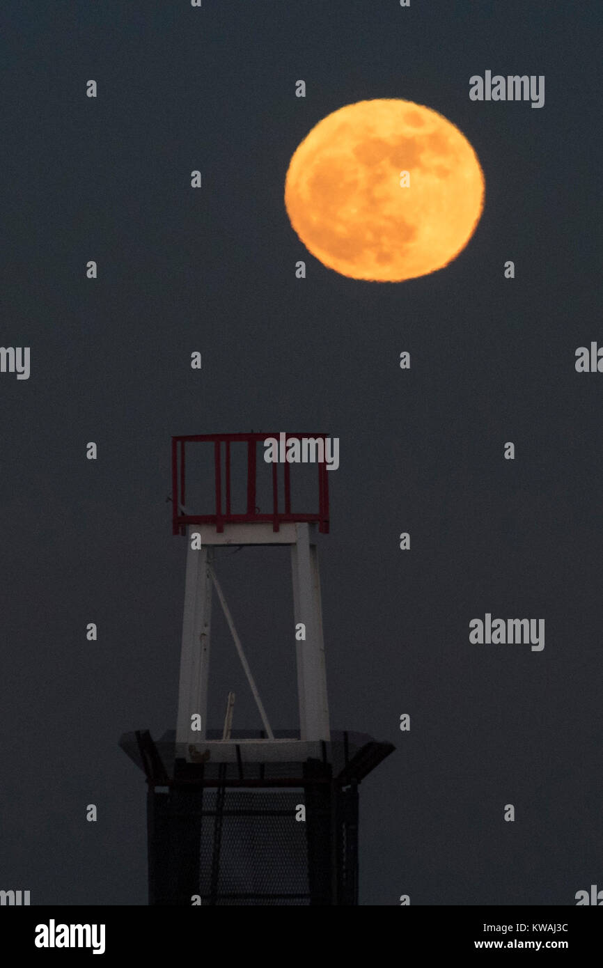 Chicago, Stati Uniti d'America. 1a gen, 2018. Il supermoon sorge a ridosso del molo al coperto di ghiaccio North Avenue beach su uno del più freddo Capodanno in decenni. La luna è al suo punto più vicino, il perigeo, a terra durante la sua orbita mensile e compare il 30% più luminoso e 14% più grande. Gennaio 2018 vede un supermoon noto come 'Wolf moon" il 1 gennaio e un "Blue Moon" il 31 gennaio. Credito: Stephen Chung/Alamy Live News Foto Stock