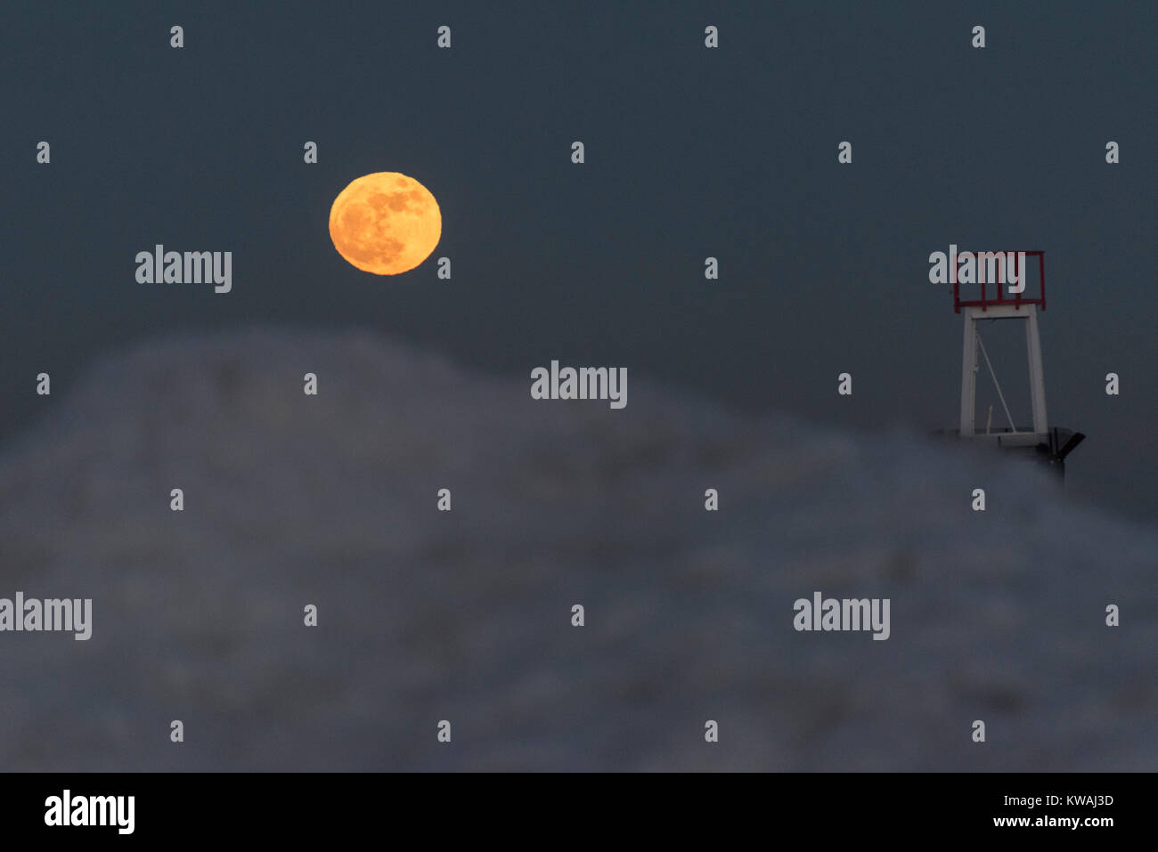 Chicago, Stati Uniti d'America. 1a gen, 2018. Il supermoon sorge a ridosso del molo al coperto di ghiaccio North Avenue beach su uno del più freddo Capodanno in decenni. La luna è al suo punto più vicino, il perigeo, a terra durante la sua orbita mensile e compare il 30% più luminoso e 14% più grande. Gennaio 2018 vede un supermoon noto come 'Wolf moon" il 1 gennaio e un "Blue Moon" il 31 gennaio. Credito: Stephen Chung/Alamy Live News Foto Stock