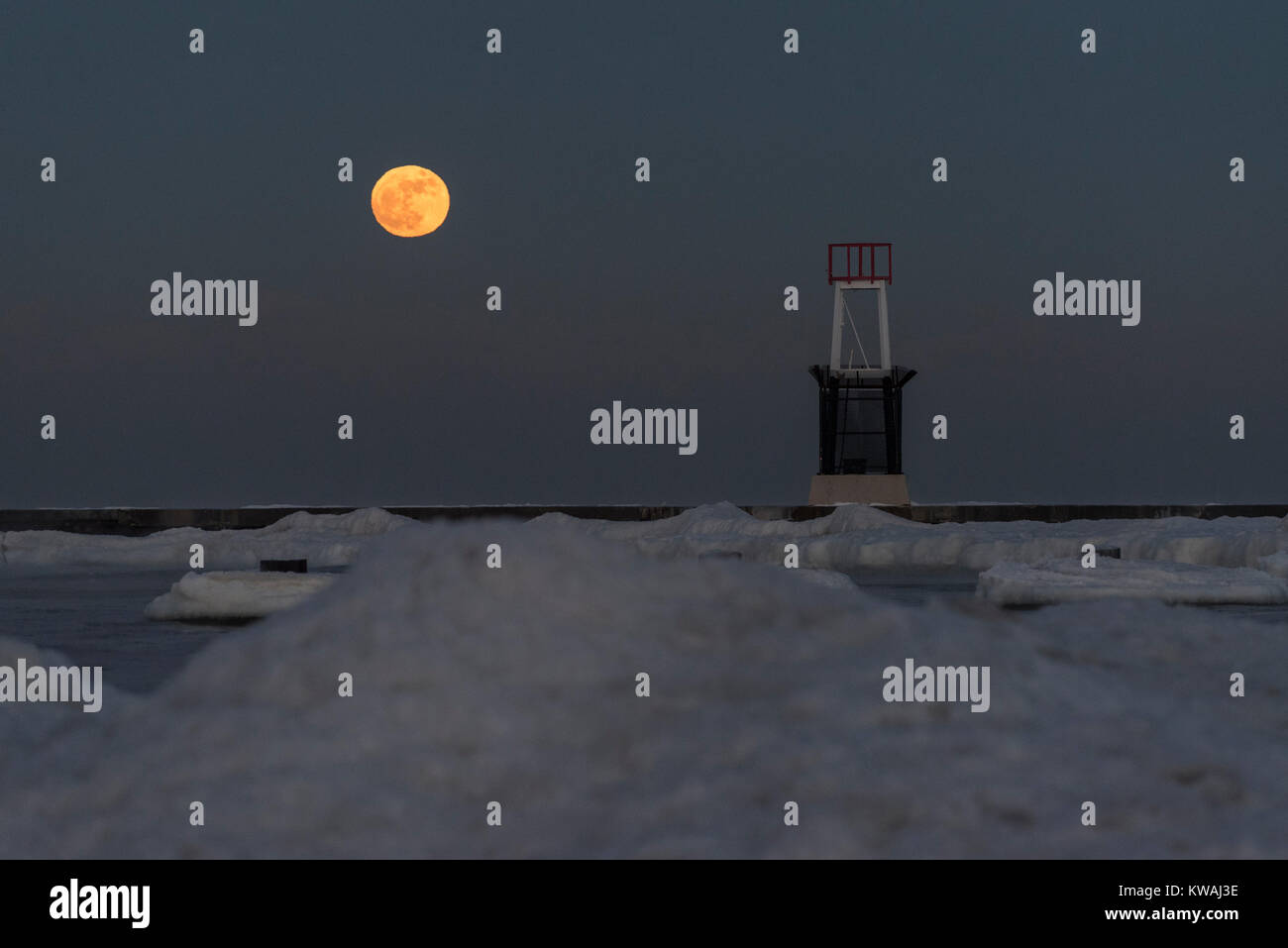 Chicago, Stati Uniti d'America. 1a gen, 2018. Il supermoon sorge a ridosso del molo al coperto di ghiaccio North Avenue beach su uno del più freddo Capodanno in decenni. La luna è al suo punto più vicino, il perigeo, a terra durante la sua orbita mensile e compare il 30% più luminoso e 14% più grande. Gennaio 2018 vede un supermoon noto come 'Wolf moon" il 1 gennaio e un "Blue Moon" il 31 gennaio. Credito: Stephen Chung/Alamy Live News Foto Stock
