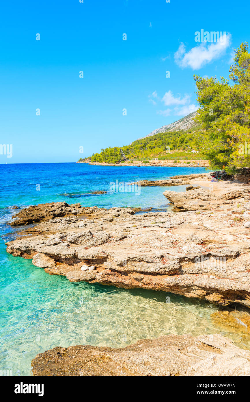 Vista della piccola baia con spiaggia tra rocce vicino al famoso capo di Zlatni Rat nella città di Bol, isola di Brac, Croazia Foto Stock