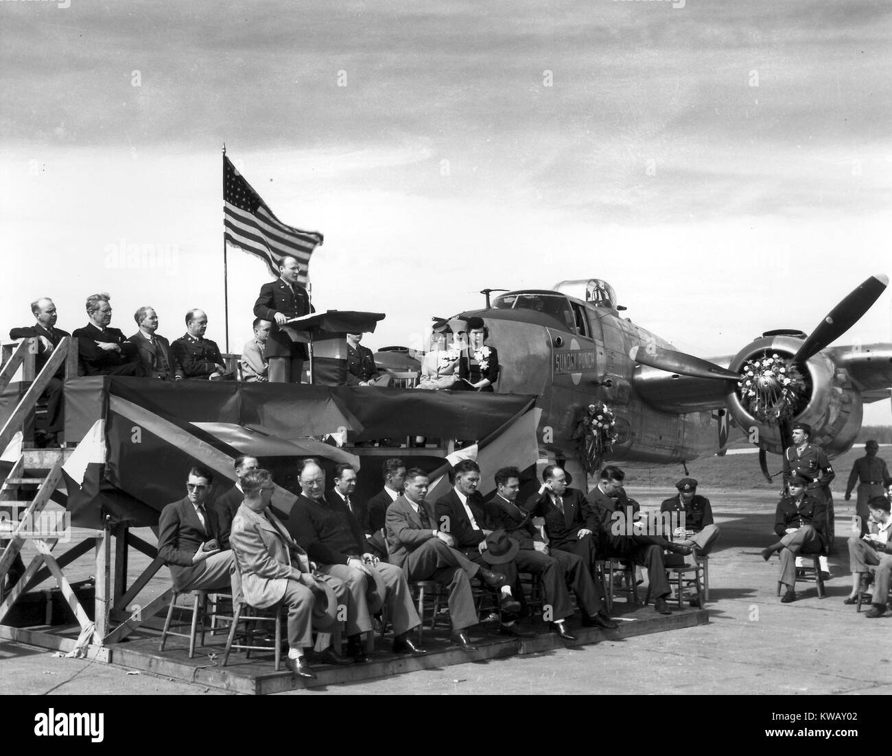 Un uomo si erge a un podio dando un indirizzo accanto alla domenica punzone, il famoso B-25 bombardiere, in Oak Ridge, Tennessee, 1945. Immagine cortesia del Dipartimento Americano di Energia. Foto Stock