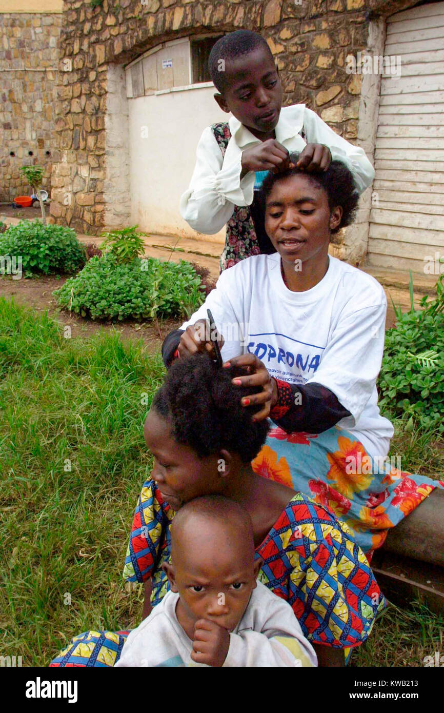 Ibanda Camp, Bukavu, sul sito di un ex corpo di pace traing center, per persone sfollate da Goma dal flusso di lava a seguito eruzione vulcanica, Jan 2002 qui i membri della famiglia braid reciprocamente i capelli. Foto Stock