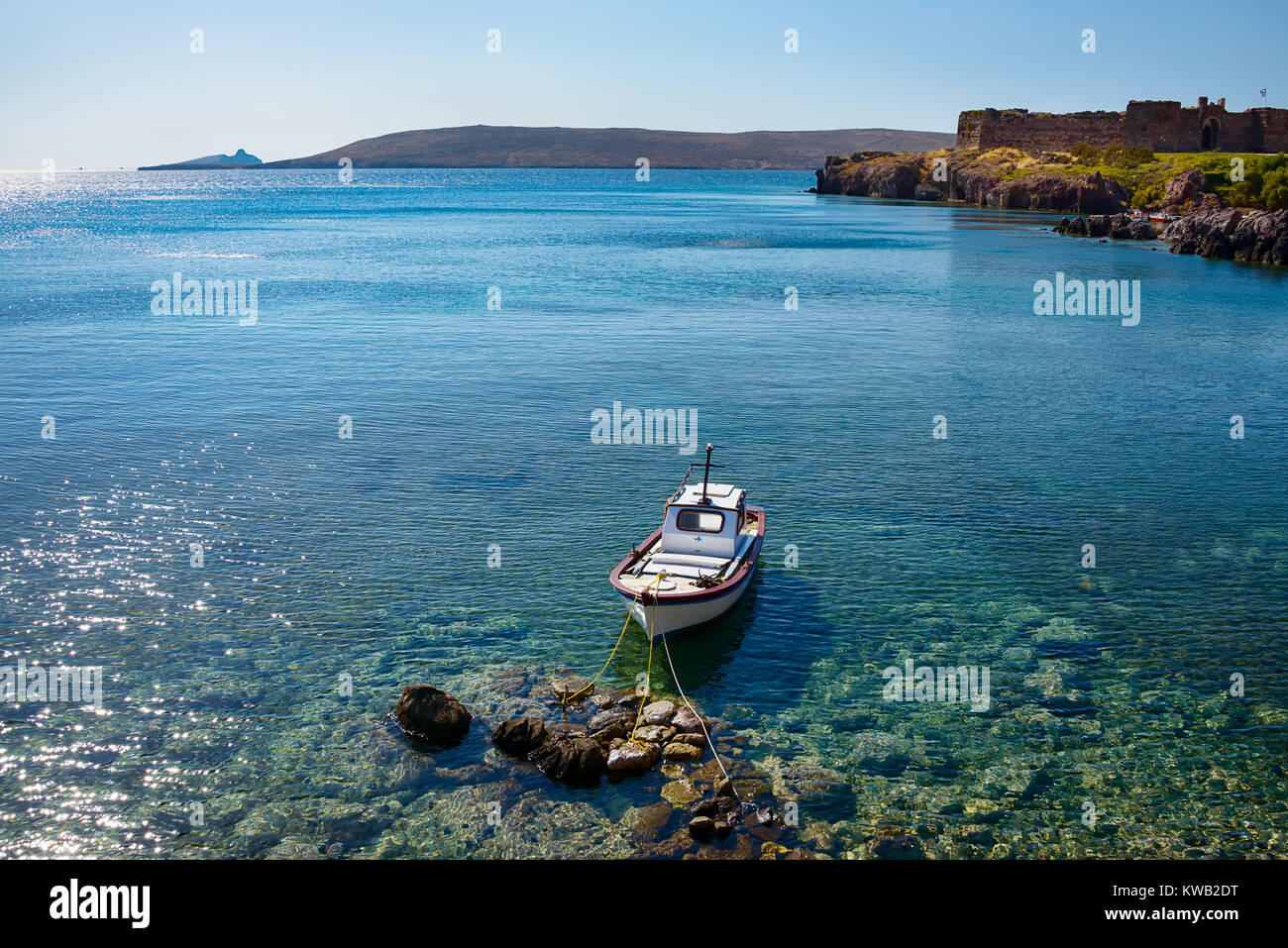 Piccola barca da pesca ormeggiate presso la costa sassosa di Sigri con il castello waterside, Lesbo, Egeo Orientale, la Grecia, l'Europa. Foto Stock