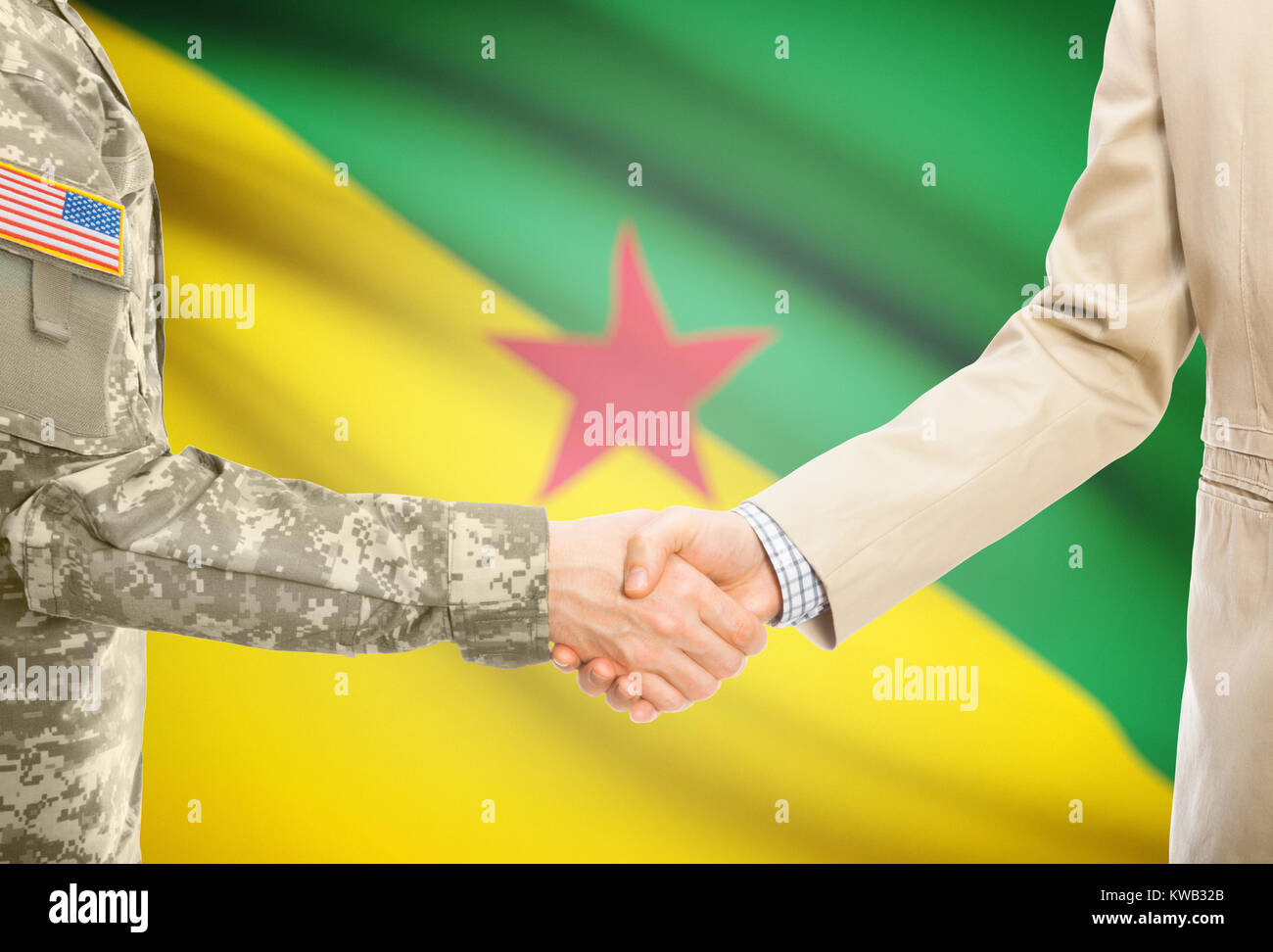 Soldato americano in uniforme e uomo civile in tuta stringono le mani con adeguata bandiera nazionale su sfondo - Guyana francese Foto Stock